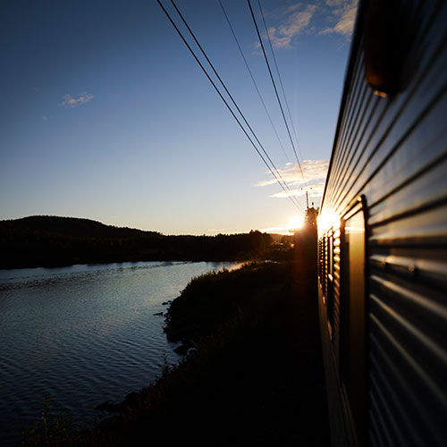 Blick auf Bahn und Landschaft mit Wasser © SJ night train